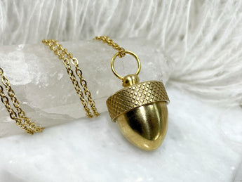 A gold acorn urn necklace with a top that unscrews. This makes a great keepsake for items larger than ashes.